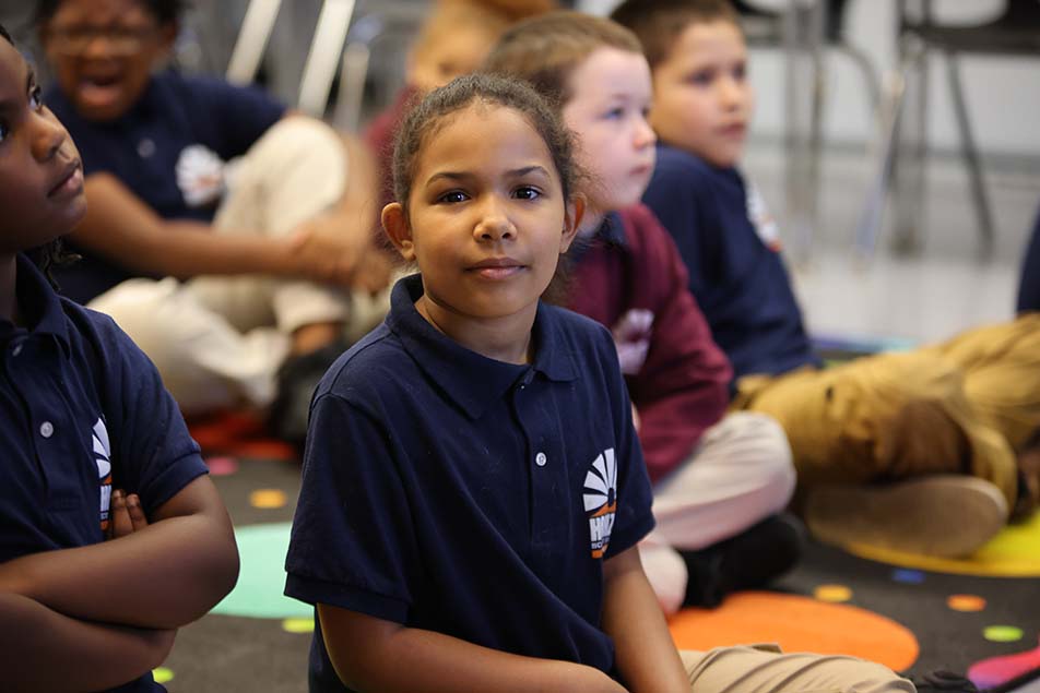 student in classroom smiling at camera